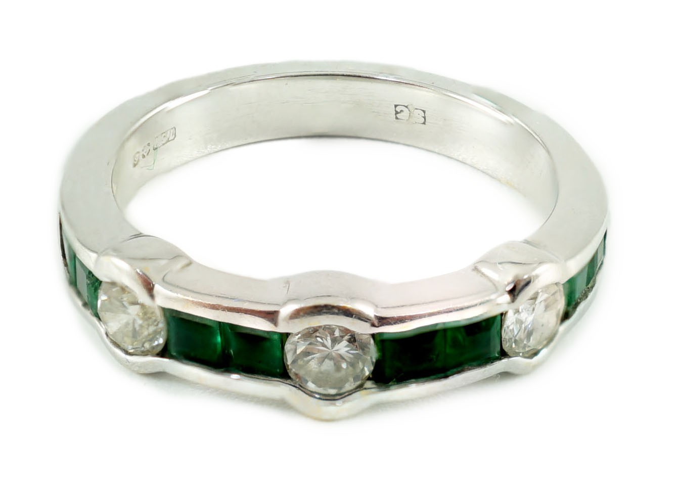 A modern 18ct white gold, square cut emerald and round cut diamond set half eternity ring